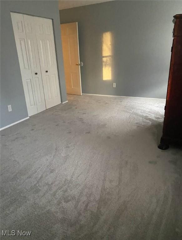 unfurnished bedroom with a closet and carpet flooring