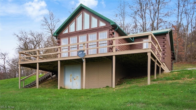 back of house with a deck and a lawn