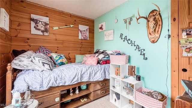 carpeted bedroom featuring wood walls