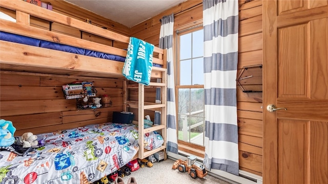 bedroom featuring carpet flooring and wood walls