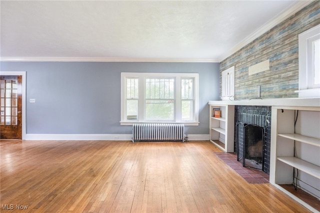 unfurnished living room featuring radiator, light hardwood / wood-style floors, and ornamental molding