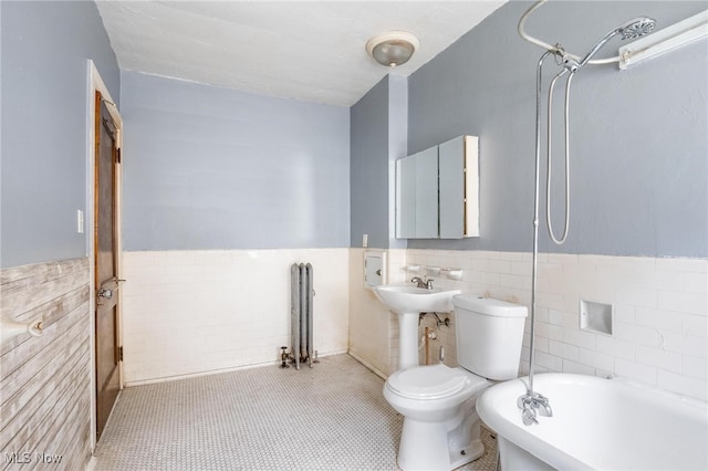 bathroom with radiator heating unit, tile patterned floors, toilet, shower / washtub combination, and tile walls