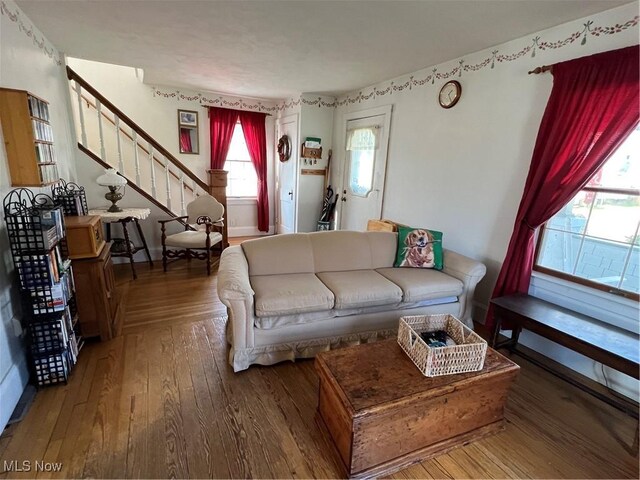 living area featuring hardwood / wood-style floors and stairway