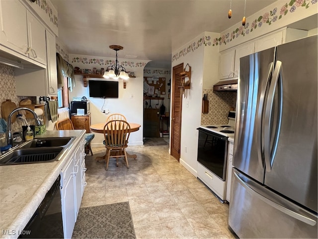 kitchen with stainless steel refrigerator, sink, hanging light fixtures, a notable chandelier, and white electric stove