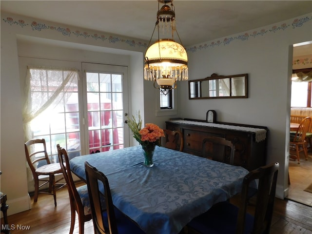 dining area featuring plenty of natural light, an inviting chandelier, and hardwood / wood-style flooring