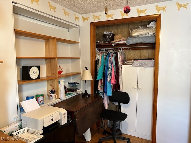 home office featuring hardwood / wood-style floors and a textured ceiling