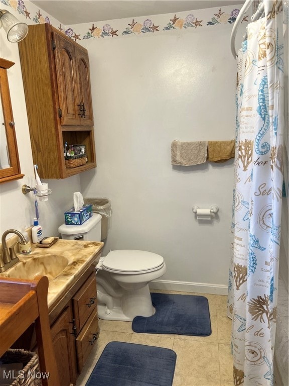 bathroom with toilet, vanity, tile patterned floors, and walk in shower