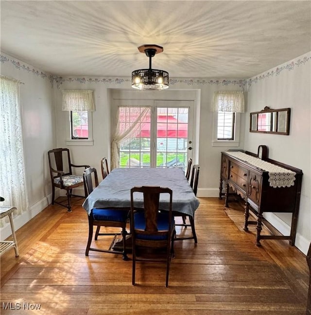 dining area with plenty of natural light, hardwood / wood-style flooring, and baseboards