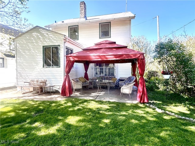back of property featuring a gazebo, an outdoor hangout area, a yard, a patio, and a chimney