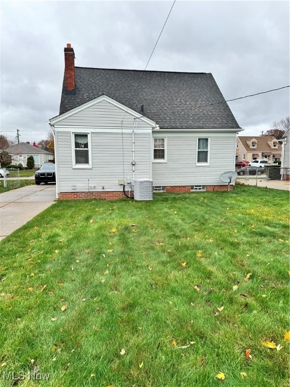 rear view of house featuring a yard and cooling unit