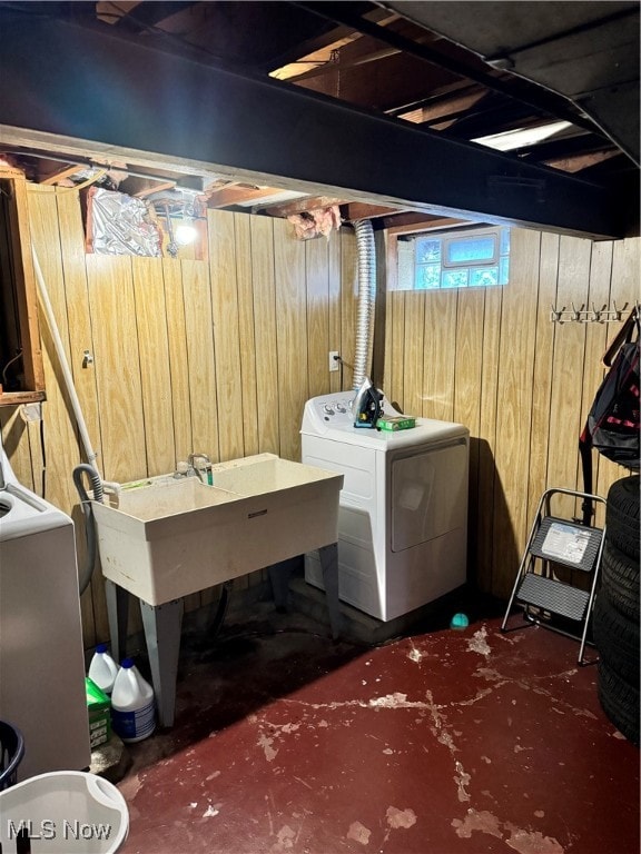 laundry area featuring wood walls and washer / dryer