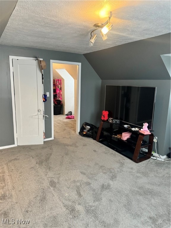 bonus room featuring a textured ceiling, carpet floors, and lofted ceiling