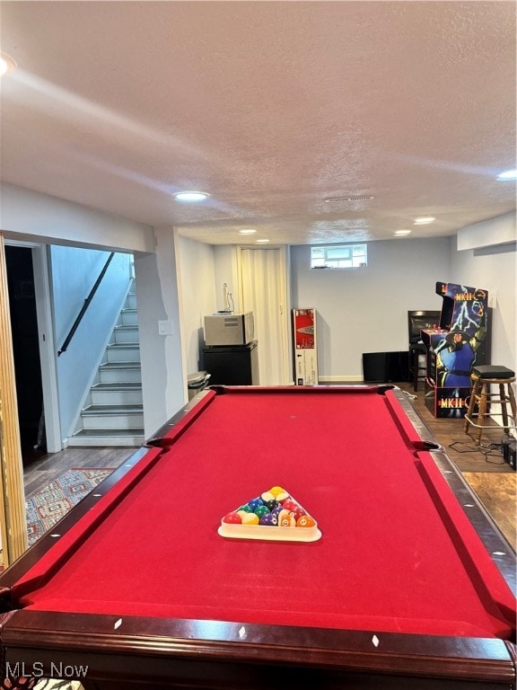 playroom with wood-type flooring, a textured ceiling, and pool table