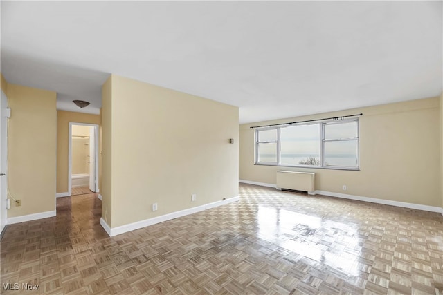 unfurnished room with radiator and light parquet flooring