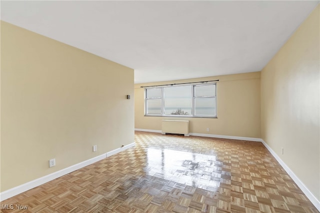 empty room with radiator and light parquet flooring