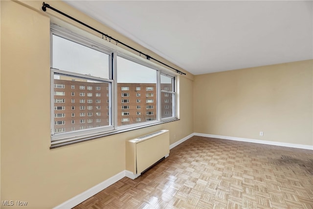 unfurnished room featuring radiator and light parquet floors