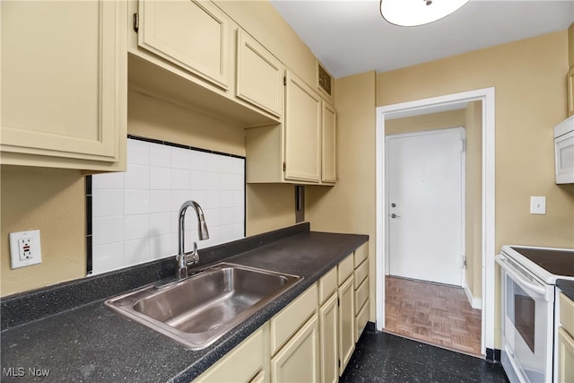 kitchen with backsplash, white appliances, sink, and cream cabinetry