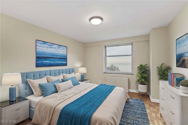 bedroom with radiator and light parquet floors