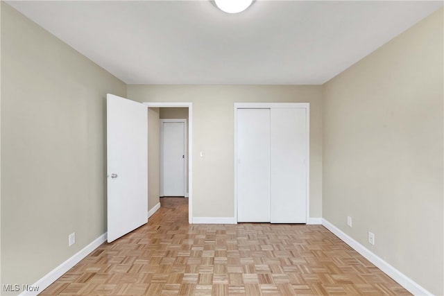 unfurnished bedroom with a closet and light parquet flooring