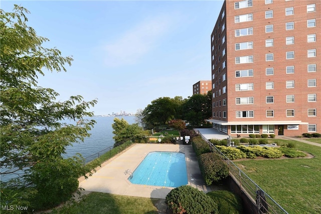 view of pool featuring a water view and a patio