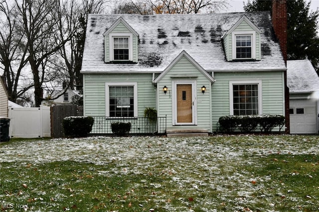 cape cod home featuring a front lawn