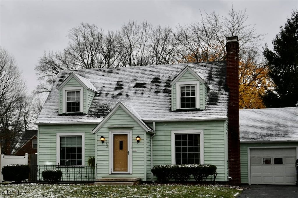 cape cod home featuring a garage