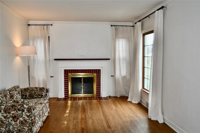 unfurnished living room with crown molding, hardwood / wood-style floors, and a brick fireplace