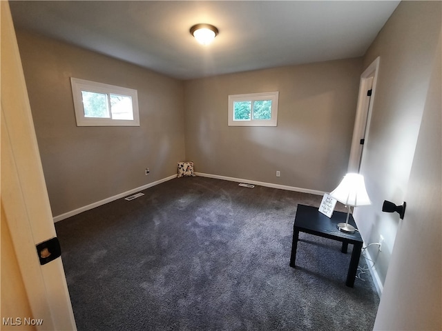 empty room with dark colored carpet