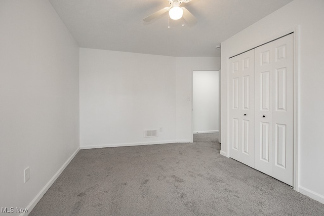 unfurnished bedroom featuring ceiling fan, a closet, and light colored carpet