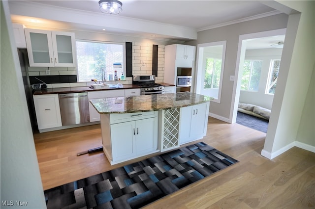 kitchen featuring decorative backsplash, white cabinetry, sink, and appliances with stainless steel finishes