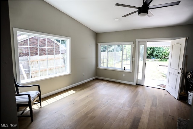 interior space with ceiling fan, a healthy amount of sunlight, vaulted ceiling, and hardwood / wood-style flooring