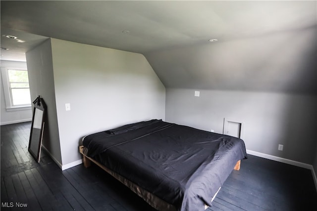 bedroom with dark hardwood / wood-style floors and lofted ceiling