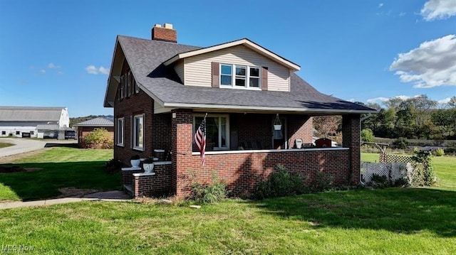 view of front of house with covered porch and a front lawn