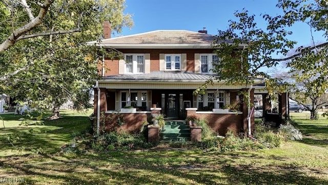 view of front facade with covered porch and a front yard