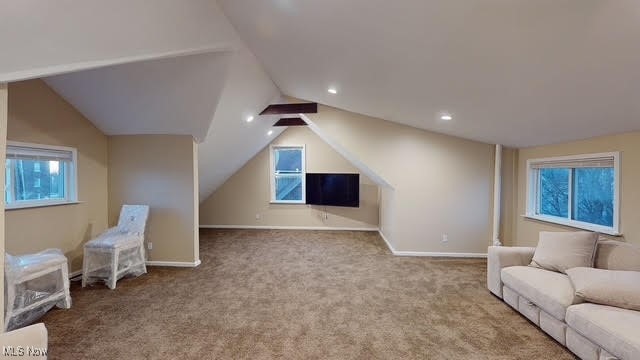 interior space with light colored carpet and vaulted ceiling