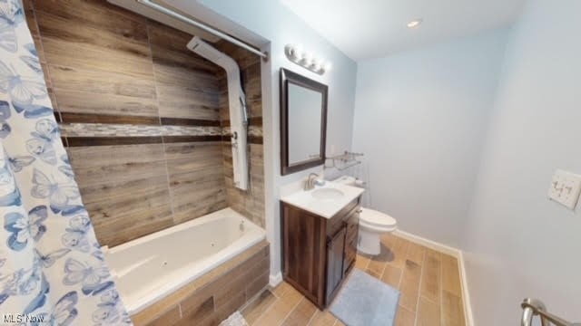 full bathroom featuring hardwood / wood-style flooring, vanity, toilet, and shower / bathtub combination with curtain