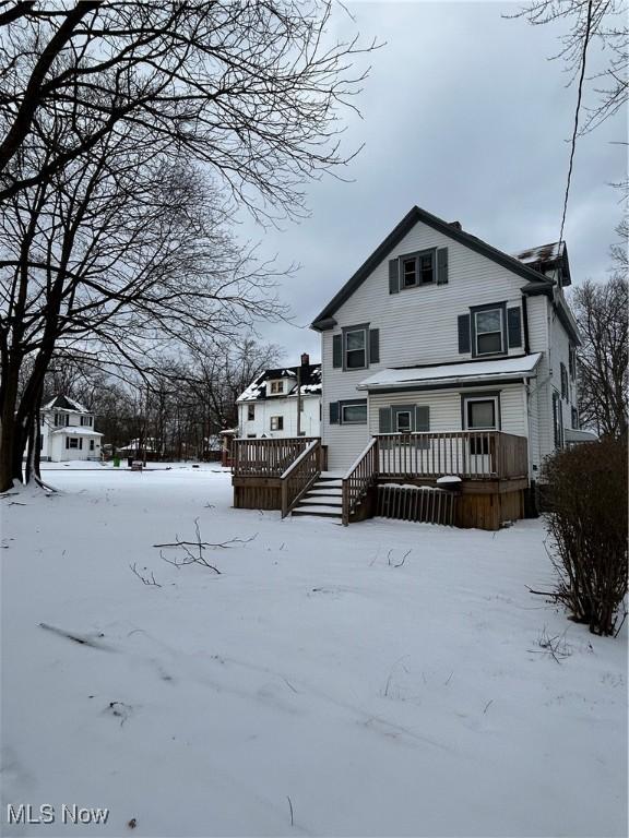 view of snow covered rear of property