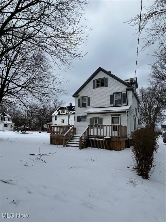 view of snow covered rear of property