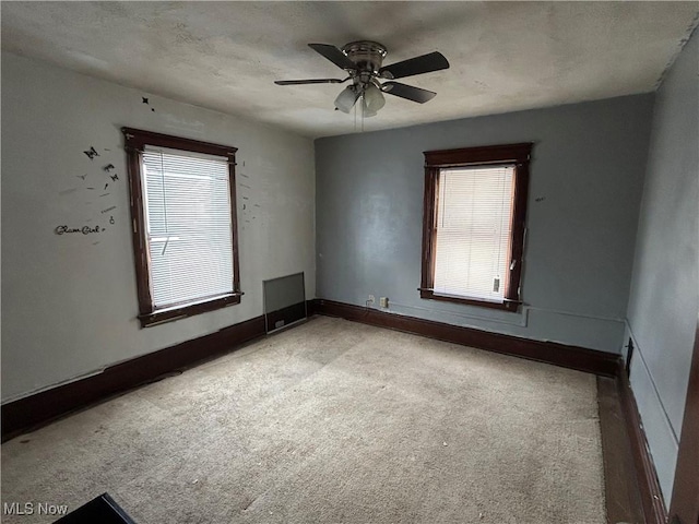 spare room with ceiling fan and plenty of natural light