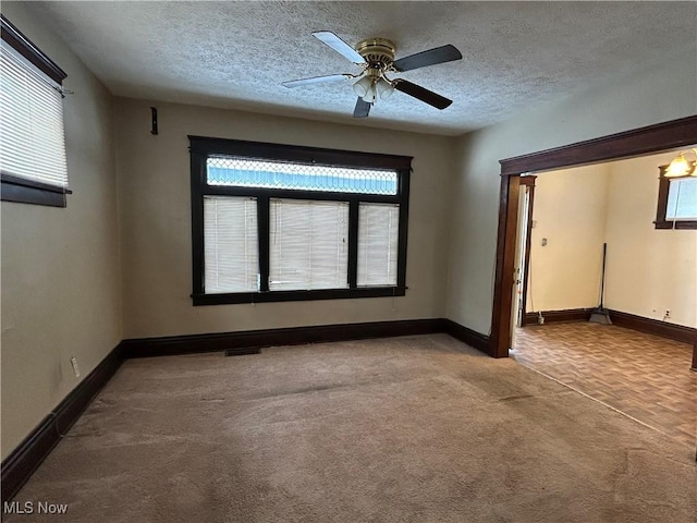 carpeted spare room with ceiling fan and a textured ceiling