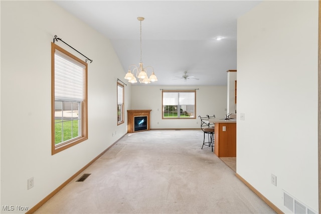 living room featuring light carpet, ceiling fan with notable chandelier, and vaulted ceiling