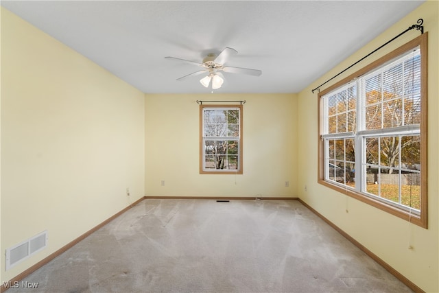 carpeted spare room featuring ceiling fan