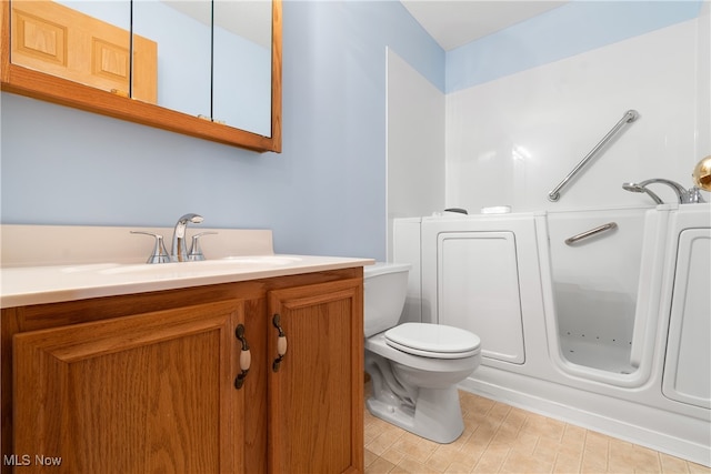 bathroom with vanity, toilet, and a tub to relax in