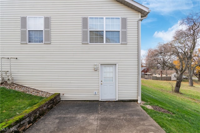 view of side of property featuring a yard and a patio