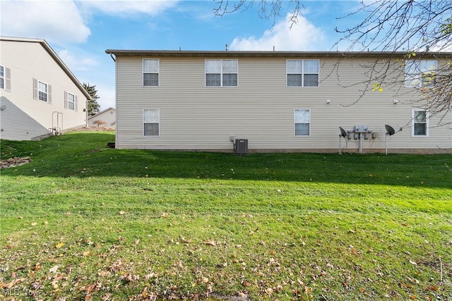 back of house with a yard and central air condition unit