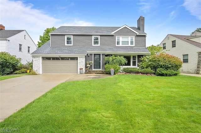 view of front of property featuring a front lawn and a garage