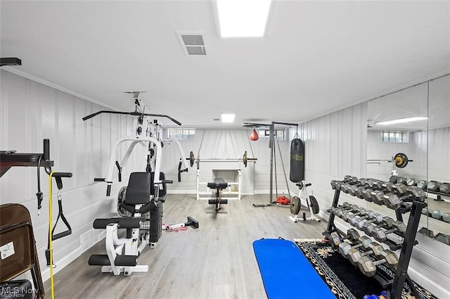 workout area with wood-type flooring and ornamental molding