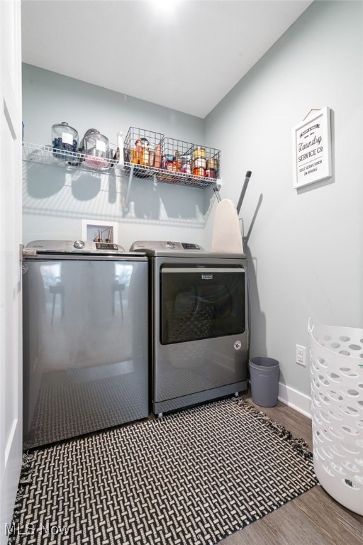 clothes washing area featuring wood-type flooring and washing machine and clothes dryer