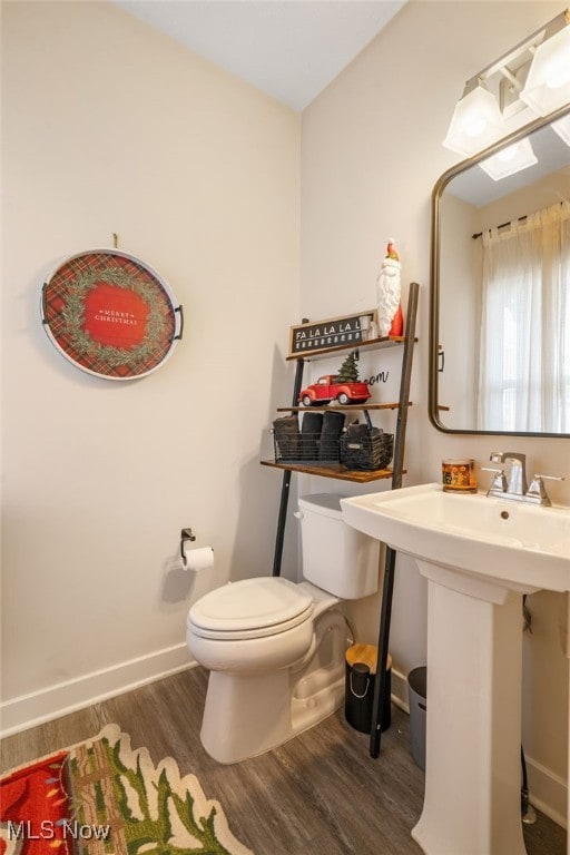 bathroom featuring sink, wood-type flooring, and toilet