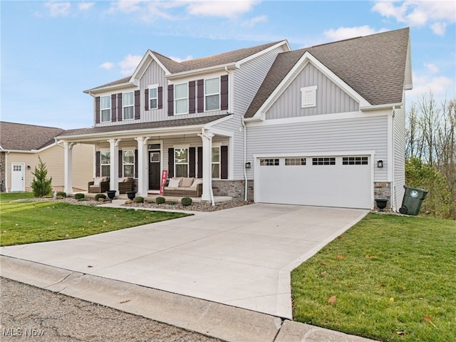 view of front of property featuring covered porch, a garage, and a front lawn